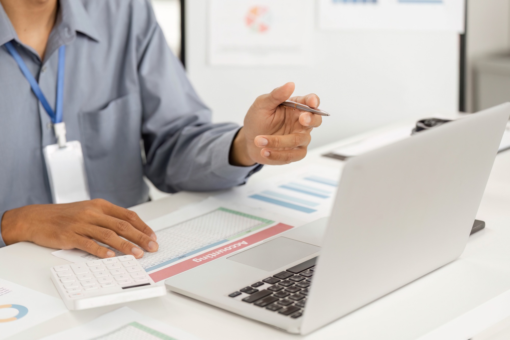 Remote Work and Digital Transformation. Professional analyzing data on laptop with documents.