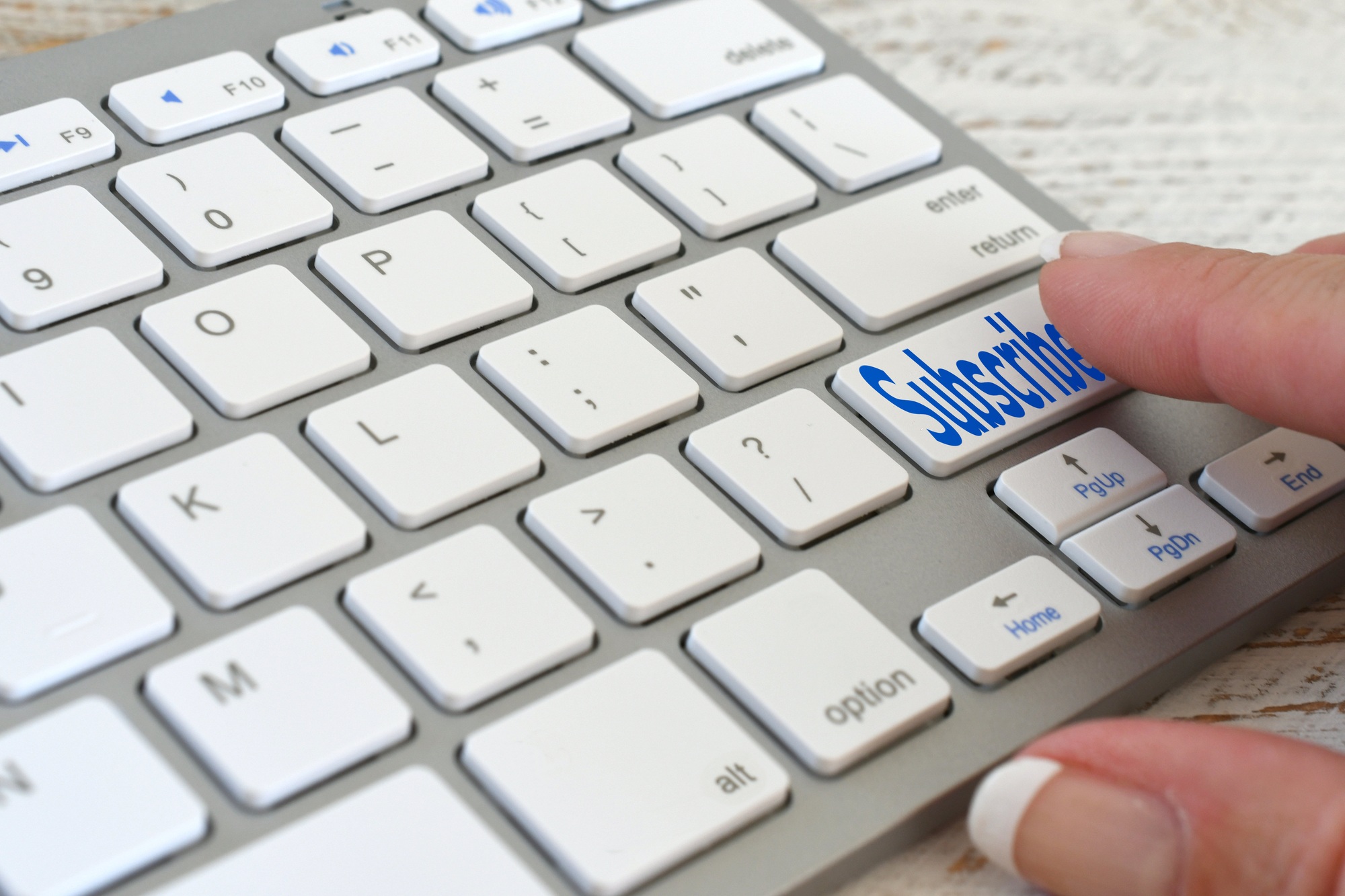 Woman pushing a Subscribe button subscribing to an online service - sign up Keyboard concept