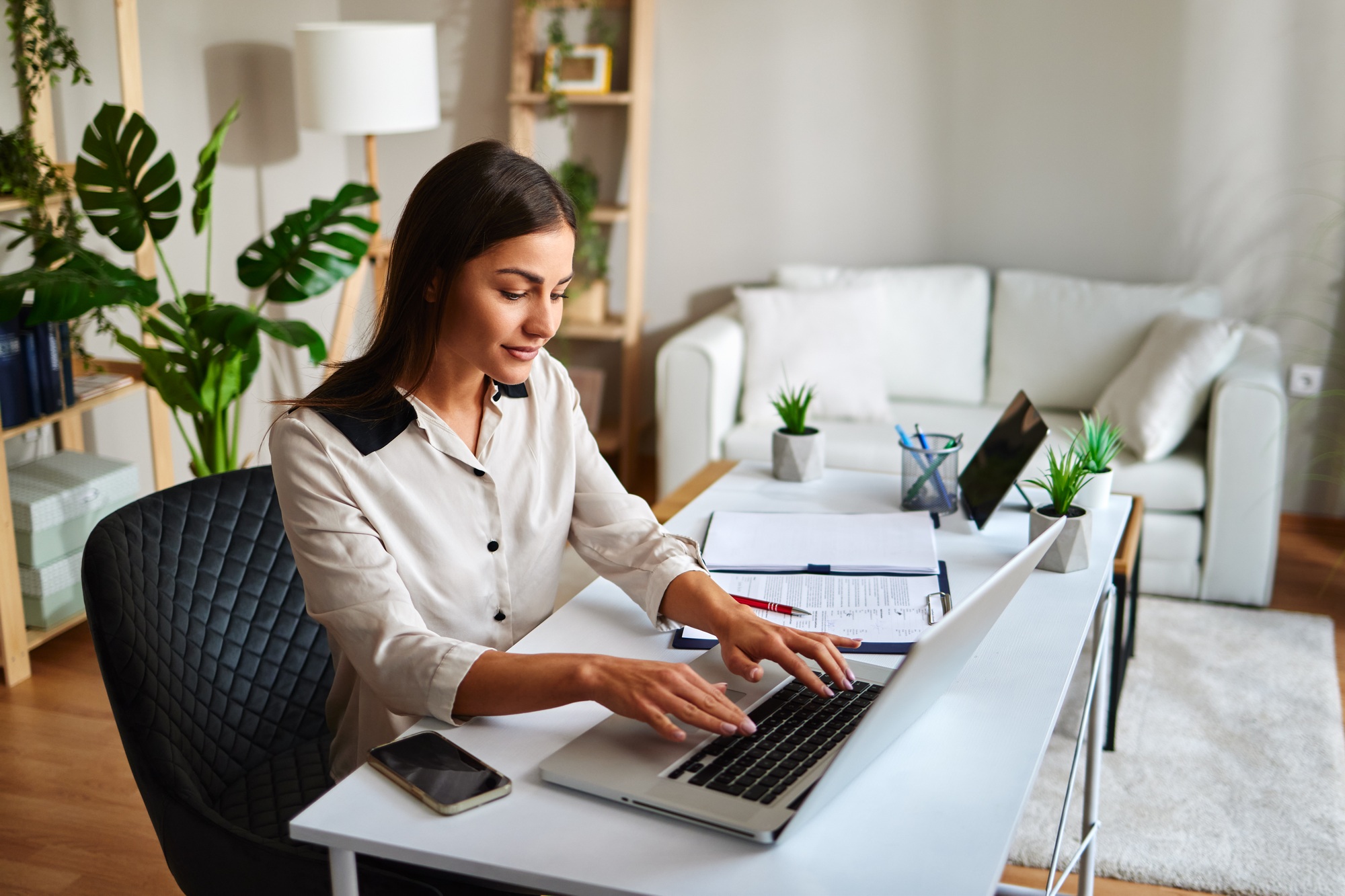 Young businesswoman working from home typing on laptop computer