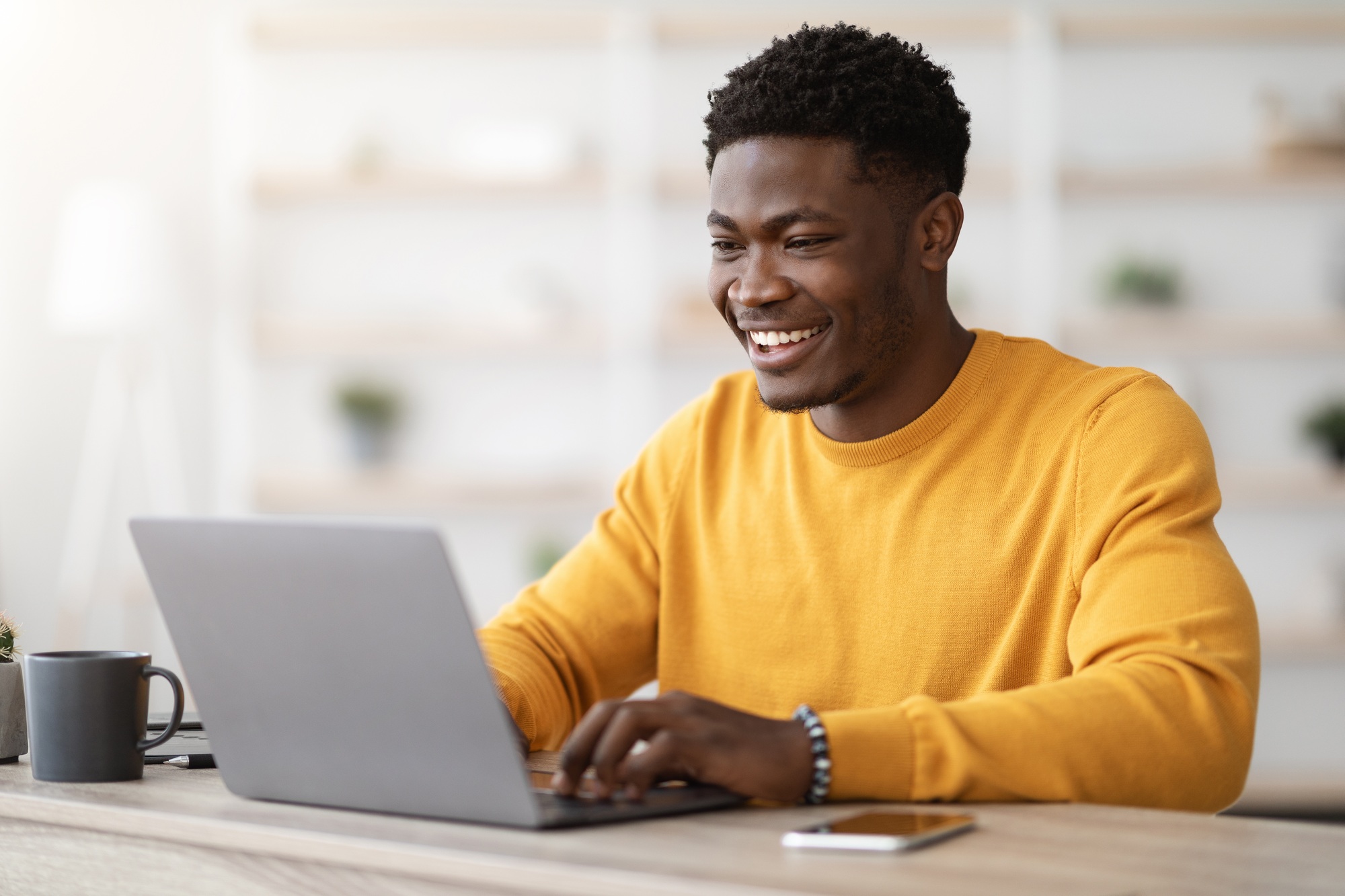 Successful black guy project manager typing on laptop keyboard